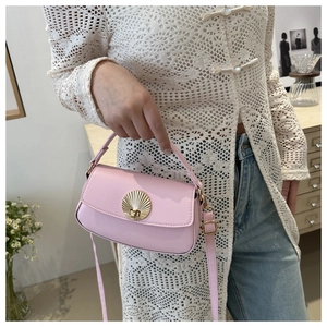 Detailed close-up of a pink mini crossbody bag with a golden shell-shaped twist lock