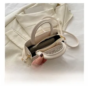 Top view showing the spacious interior with black lining and gold zipper of the cream bag