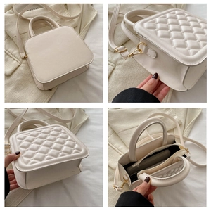 Detailed interior of quilted crossbody bag showing dual compartments and gold hardware