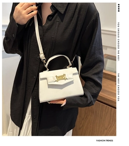 Dettaglio mini borsa a tracolla bianca stile Kelly con catena dorata e sottile tracolla regolabile