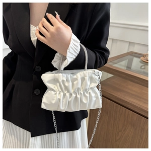 Detail van de witte geplooide crossbody tas met parelhandvat en metalen ketting