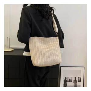 Détail d'un sac cabas tissé beige avec texture verticale et large bandoulière en tissu
