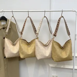 Straw woven crossbody bags with patterned straps in assorted neutral summer colors
