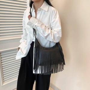Minimalist black pebble leather hobo bag with tassel detail for daily commute