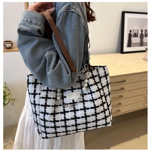 Detail of checkered tweed tote bag with faux pearl strap and leather shoulder handle
