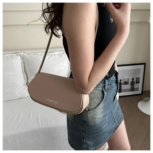 Vue latérale du sac selle en cuir beige avec imprimé Fashion sur l'épaule du mannequin