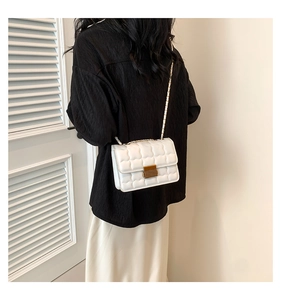 Détail du sac blanc matelassé à texture bulle avec fermoir doré et bandoulière