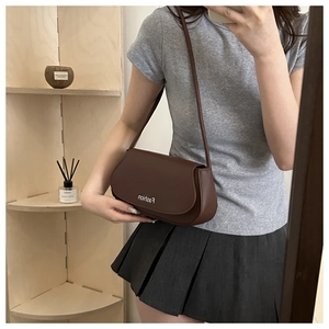 Sacoche marron foncé style français en cuir portée à l'épaule pour un look décontracté