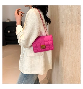 Détail du sac bandoulière matelassé rose avec chaîne dorée et fermoir en métal sur modèle