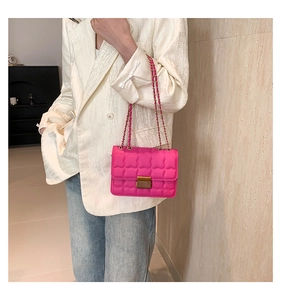 Détail d'un sac à chaîne matelassé rose vif avec boucle dorée et bandoulière chic