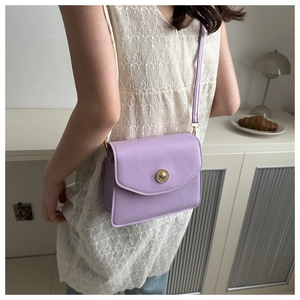 Détail du sac bandoulière tofu lilas avec une boucle dorée ronde et sa fine bandoulière