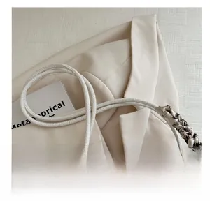 Detail showing the woven texture and decorative silk scarf on the white tote bag handle