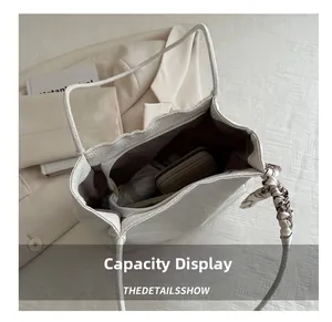 Detail shot of white textured tote bag interior showing spacious capacity and silk scarf