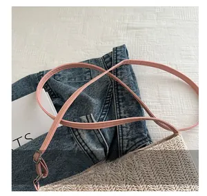 Detail of woven straw tote with pink adjustable PU shoulder strap and silver metal buckle