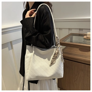 Detailed view of a white tote bag featuring fine twill texture and a printed silk scarf handle