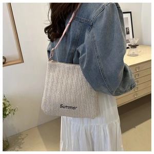 Detail of Summer letter embroidery on woven straw tote with pink shoulder strap