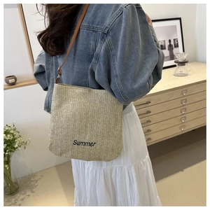 Detail of Summer embroidery and thin brown leather strap on the straw tote bag