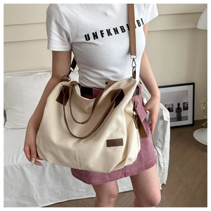 Lifestyle view of large canvas tote bag with brown straps and fashion patch detail