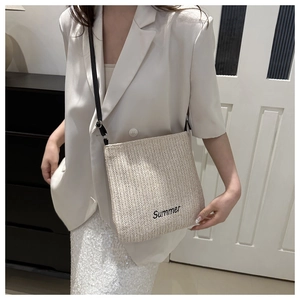 Detail of the Summer embroidery and woven texture on this large cream straw tote bag