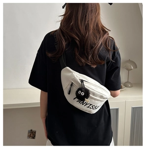 Back view of white canvas crossbody bag with FANYISSA print and black soot sprite charm