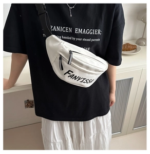 Detail van een witte canvas schoudertas met FANYISSA print en zwarte nylon band