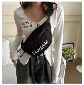 Crossbody bag detail showing FANYISSA printed lettering on black canvas material