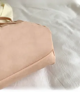 Close-up of lightweight textured fabric and stitching on pink tote shoulder bag
