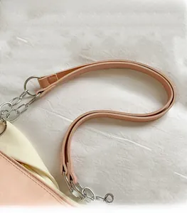 Close-up of pink leather shoulder strap and silver metal chain on a stylish tote bag