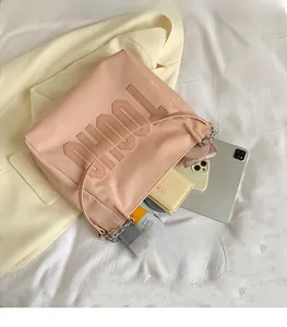 Detail of spacious pink tote bag with TOUGH lettering and essentials inside
