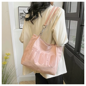 Detail of pink faux leather tote bag with TUOHO embossed letters and silver metal chain strap