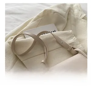 Détail du sac besace en cuir blanc crème orné d'une boucle nœud argentée élégante