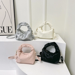 Ruched pleated handbags in silver, white, pink, and black colors on display