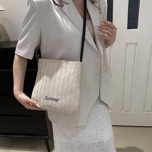 Large beige woven straw tote bag with black Summer embroidery and slim shoulder strap
