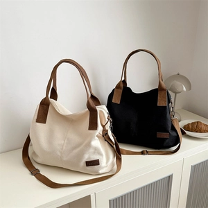 Minimalist canvas tote bag in beige and black with contrast straps for daily commute