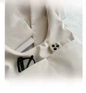 Détail du sac cabas en cuir blanc présentant une grande poche extérieure fonctionnelle