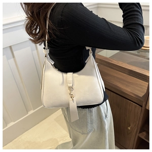 Detail of minimalist beige leather underarm bag with sleek metallic hook clasp closure