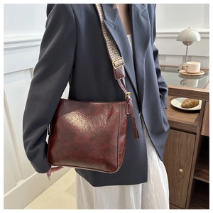 Détail d'un sac seau marron vintage avec large bandoulière à motif pied-de-poule