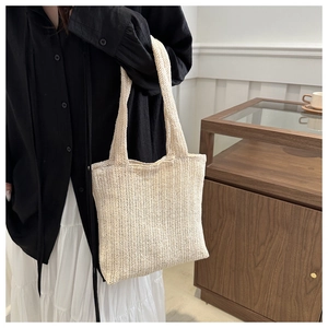 Detailed macro view of cream woven tote bag texture and handcrafted knitting pattern