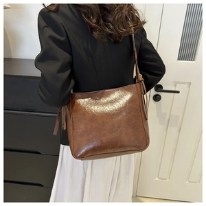 Détail du sac seau marron vintage montrant la texture cirée et la boucle métallique