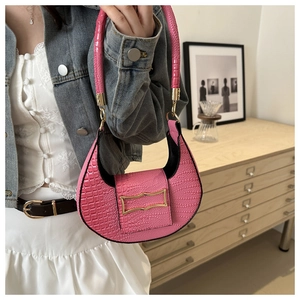 Detail of pink croc-effect crescent bag with elegant wave-shaped gold metal buckle