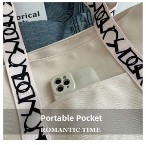Détail de la poche avant du sac cabas en toile avec smartphone et bandoulière imprimée