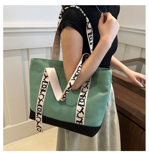 Détail de la bandoulière large et coutures contrastées sur le sac en toile vert