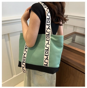 Détail du sac fourre-tout en toile avec large bandoulière graphique élégante et patchwork