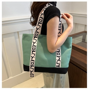 Détail du sac cabas en toile vert menthe avec larges anses et base noire