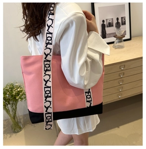 Détail du sac fourre-tout en toile rose et noir avec large bandoulière géométrique