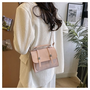 Detailed back view of model wearing pink PU leather crossbody bag with silver buckle