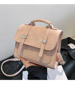 Close-up of pink matte texture handbag with silver metal buckles and top handle