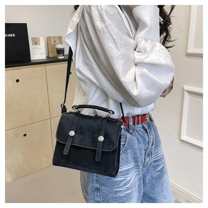 Detailed side view of black vintage flap crossbody bag with silver buckle accents