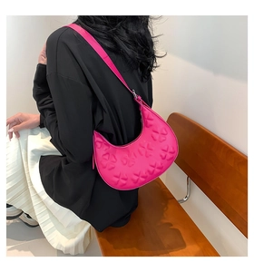Detail of rose pink semi-circle bag with 3D clover embossing and sleek shoulder strap