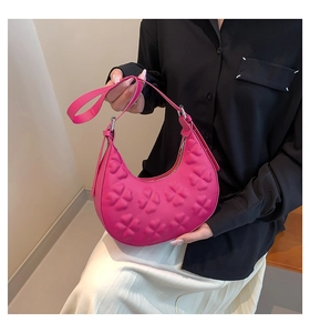Close-up of pink hobo bag with embossed floral pattern and slim shoulder strap
